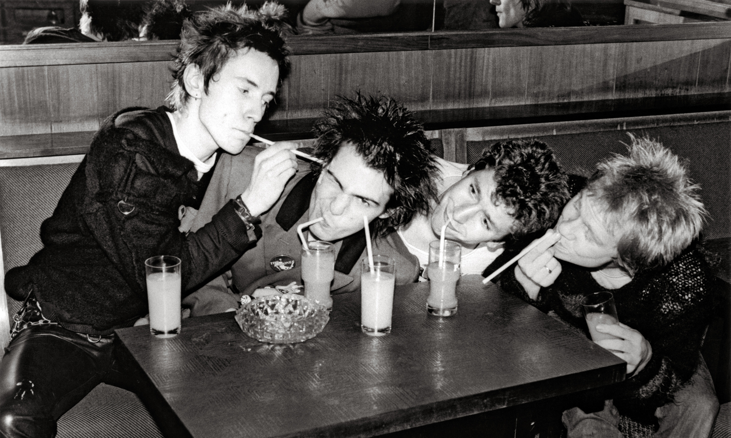 (I-D) Johnny Rotten, Sid Vicious, Steve Jones y Paul Cook juegan con pitillos en Luxembourg en noviembre de 1977. © Bob Gruen