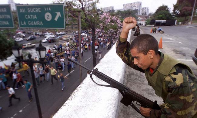 Un soldado saluda a los partidarios del depuesto presidente Hugo Chávez en la base militar frente al Palacio Presidencial de Miraflores en Carracas el 13 de abril del 2002.