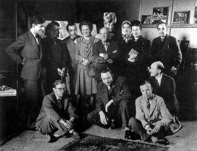 Reunión para una lectura de la obra "El deseo atrapado por la cola" de Picasso realizada el 16 de junio de 1944 en el estudio de Picasso en el nº 7 de la Rue des Grands-Augustins de París. Fila de arriba (izquierda a derecha): Jacques Lacan, Cecile Eluard, Pierre Reverdy, Louis Leiris, Pablo Picasso, Zanie Campan, Valentine Hugo, Simone de Beauvoir, Brassaï. Fila de abajo: Jean-Paul Sartre, Albert Camus, Michel Leiris, Jean Abier.