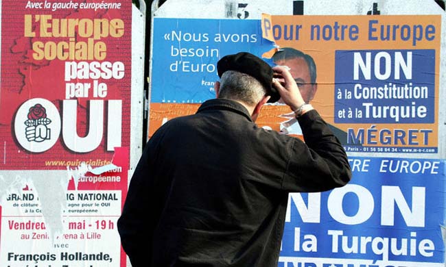 Un francés mira afiches publicitarios sobre el referéndum constitucional en Europa.