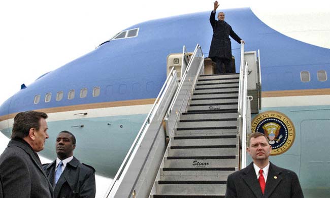 El presidente George W. Bush saluda tras su arribo a la base aérea de Rhein-Main en Frankfurt mientras el canciller Gerhard Schroeder (I) lo espera en tierra el 23 de febrero del 2005.